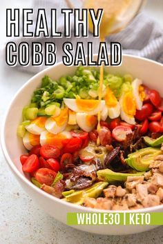 healthy cobb salad with tomatoes, lettuce and other vegetables in a white bowl