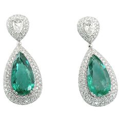 Exuding elegance and timeless sophistication, these earrings feature a stunning pair of IGI certified pear cut green emeralds, weighing approximately 13 carats in total. These exquisite emeralds are the centerpiece of the design, displaying a vivid and captivating hue that is sure to draw the eye. Accentuating the luster of the emeralds are two GIA certified pear-shaped diamonds, each weighing 0.70 carats. One of these diamonds is graded F in color and VS2 in clarity, offering a near-flawless sparkle, while the other is an E color and VS2 clarity, presenting an exceptional whiteness and brilliance. These remarkable stones are set in a meticulously crafted 18K white gold setting, which weighs 25.82 grams, providing a secure and opulent foundation for the jewels. Surrounding the central ston Emerald Diamond Earrings, Emerald Earrings, Fine Jewels, Pear Shaped Diamond, Green Emerald, Dream Jewelry, Emerald Diamond, Pear Cut, Brilliant Cut Diamond