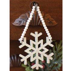 a wooden snowflake hanging on a wall next to a christmas ornament