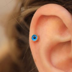 a woman's ear with a blue stone in the middle