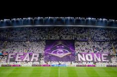 a soccer stadium filled with lots of people and fans holding up signs that read fear no one