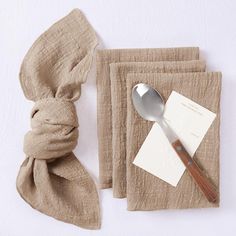 a napkin, fork and spoon on a table