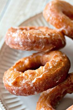 several glazed donuts on a white plate