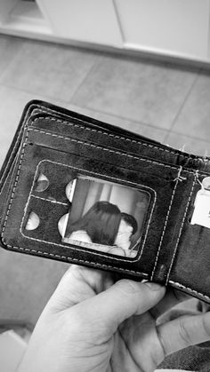 a person holding an open wallet with a dog in the back pocket and two pictures on it