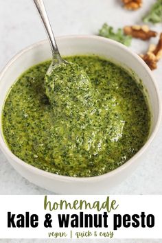 homemade kale and walnut pesto in a white bowl with a spoon on top