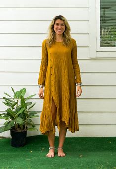 Step into effortless style with this Raw Natural Crinkled Cotton Long Sleeve Maxi Dress. Perfect for summer, this bohemian-inspired dress features a minimal design with a touch of elegance. This bohemian-style maxi dress is made from raw natural crinkled cotton, providing a soft and breathable feel. The asymmetrical hemline and front leg split add a stylish touch, while the long sleeves make it suitable for various occasions. The dress features coconut buttons, enhancing its natural and rustic charm. With a bust measurement that fits up to 50 inches and a length of 48 inches, it offers a relaxed fit for sizes S-XL. Key Features * Material: Cotton gauze * Style: Bohemian with a minimal look * Design: Asymmetrical hemline with a front leg split * Buttons: Coconut buttons * Length: 48 inches Bohemian Rayon Midi Dress For Daywear, Casual Crinkle Texture Maxi Dress For Spring, Bohemian Linen Midi Dress For Daywear, Bohemian Linen Dress For Daywear In Fall, Bohemian Linen Dress For Fall Daywear, Casual Crinkle Texture Maxi Dress For Summer, Casual Summer Maxi Dress With Crinkle Texture, Casual Crinkle Texture Midi Dress For Summer, Casual Midi Dress With Crinkle Texture For Summer