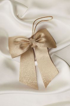 a gold bow on top of white satin