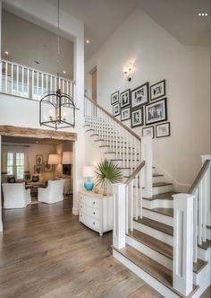 a large foyer with stairs and pictures on the wall