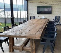 a large wooden table sitting inside of a room next to a tv on top of a hard wood floor