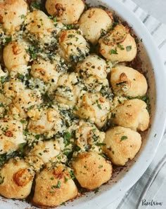 a casserole dish with bread and spinach sprinkled on top in a white bowl