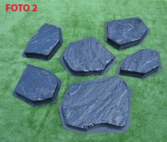 five pieces of black plastic sitting on top of green grass