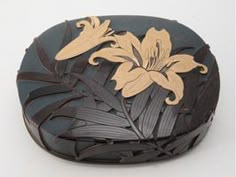 a wooden box with flowers on it sitting on a white surface, in the shape of a flower