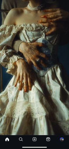 a woman in a white dress with her hands on the chest