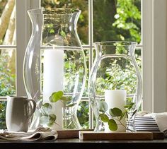 vases and other items sit on a table in front of a window