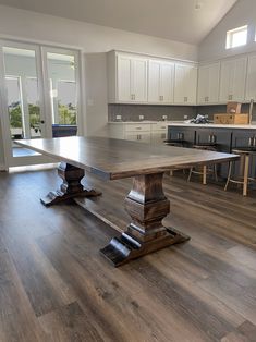 a large wooden table sitting in the middle of a kitchen