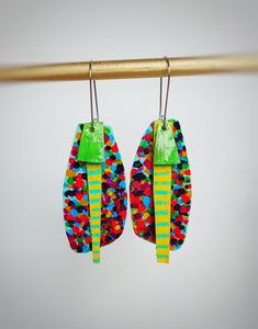 two pairs of colorful earrings hanging from a hook