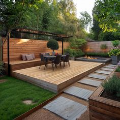 a wooden deck surrounded by plants and trees with seating area on the other side, next to an outdoor fire pit