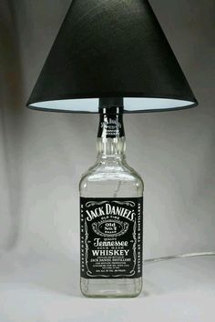 a lamp that is on top of a table with a bottle in front of it