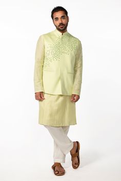 Mint green bam silk kurta with mirror embroidery. Comes with ivory cotton silk pyjama pant and a bundi with welt pockets.
Components: 3
Pattern: Hand embroidered
Type Of Work: Mirror
Neckline: Mandarin collar
Sleeve Type: Bundi : Sleeveless, Kurta : Full
Fabric: Kurta and Bundi : Bam silk, Pant : Cotton silk
Color: Green
Other Details: 
Side slits on kurta
Closure : Front buttons
Occasion: Mehendi and Haldi, Sangeet - Aza Fashions Green Chanderi Bandhgala With Zari Work, Green Chanderi Bandhgala With Cutdana, Fitted Green Chanderi Bandhgala, Green Chanderi Bandhgala For Festivals, Green Bandhgala With Resham Embroidery For Festivals, Festive Green Chanderi Sherwani, Fitted Green Bandhgala In Chanderi, Festive Nehru Jacket With Mirror Work, Festive Green Chanderi Bandhgala