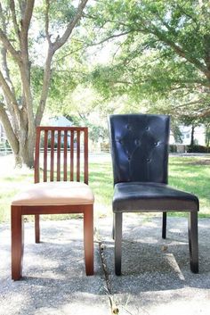 two chairs sitting next to each other in front of a tree