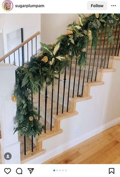 the stairs are decorated with greenery and gold ornaments for christmas time, but no one is present