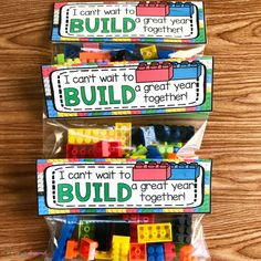 three bags filled with legos sitting on top of a wooden table