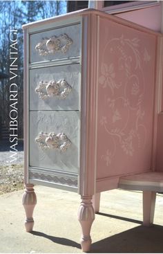 a pink and silver dresser sitting on top of a sidewalk