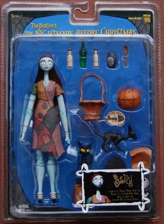 a toy doll is shown in the package for halloween decorations, including a black cat and pumpkins