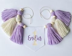 a purple and white tasselled necklace with the word'enria'written on it