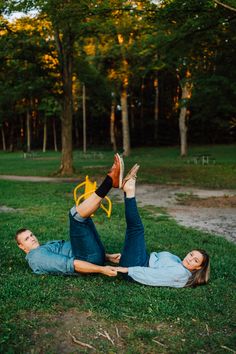 a man and woman laying on the ground with their feet up in the air next to each other