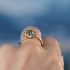 a woman's hand holding an engagement ring with a blue diamond