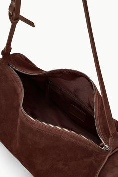 A soft suede shoulder bag with adjustable shoulder strap, the Taru can be adjusted to also be worn crossbody. This style features a zip closure and interior zip pocket.