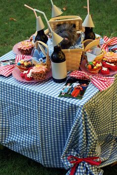 a hamster sitting in a picnic basket on top of a table