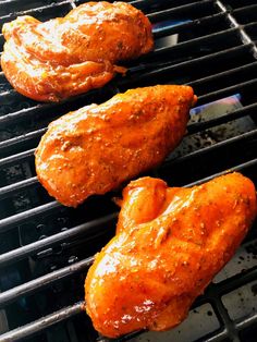 two chicken wings are cooking on the grill