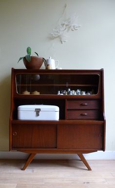 a wooden cabinet with two drawers and an ice chest in front of it on top of a hard wood floor