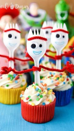 cupcakes with forks decorated as faces and candy canes in front of them