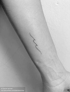 a woman's arm with the word love on it and a small wave tattoo