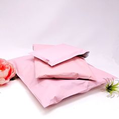 two pink envelopes and a flower on a white background