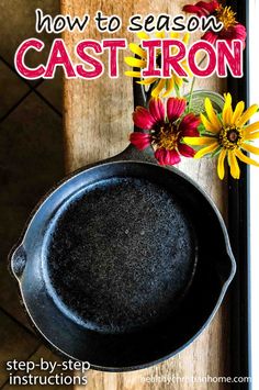 a cast iron skillet sitting on top of a wooden table with flowers in it