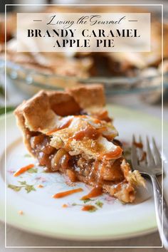 a piece of apple pie on a plate with a fork and glass bowl in the background