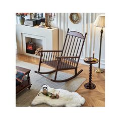 a rocking chair sitting on top of a wooden floor next to a lamp and table