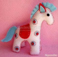 a white horse with blue ears and tail on a pink background is featured in this image