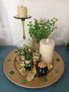 a table with a candle, potted plant and other items on it for st patrick's day