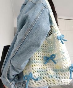 a woman carrying a crocheted bag with blue bows