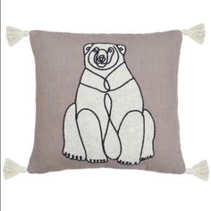 a pillow with a bear drawn on it and two tassels hanging from the side