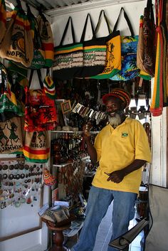 a man standing in front of a store filled with souvenir and other items