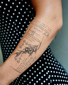 a woman with a tattoo on her arm that has an olive branch in the center