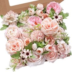 a large bouquet of pink flowers in a cardboard box