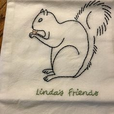 a white towel with a drawing of a squirrel on it's side and the words lindaa's friends written in green ink