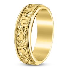 a wedding ring with an intricate design in yellow gold